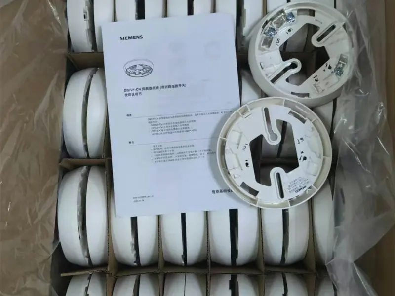Doos vol witte rookmelders en losse montagevoeten met een handleiding