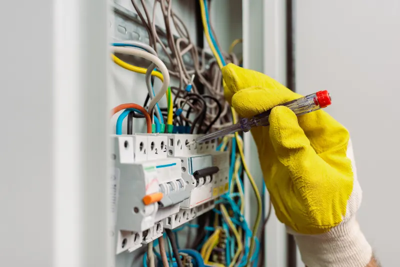 Elektricien controleert met een spanningzoeker de bedrading in een groepenkast